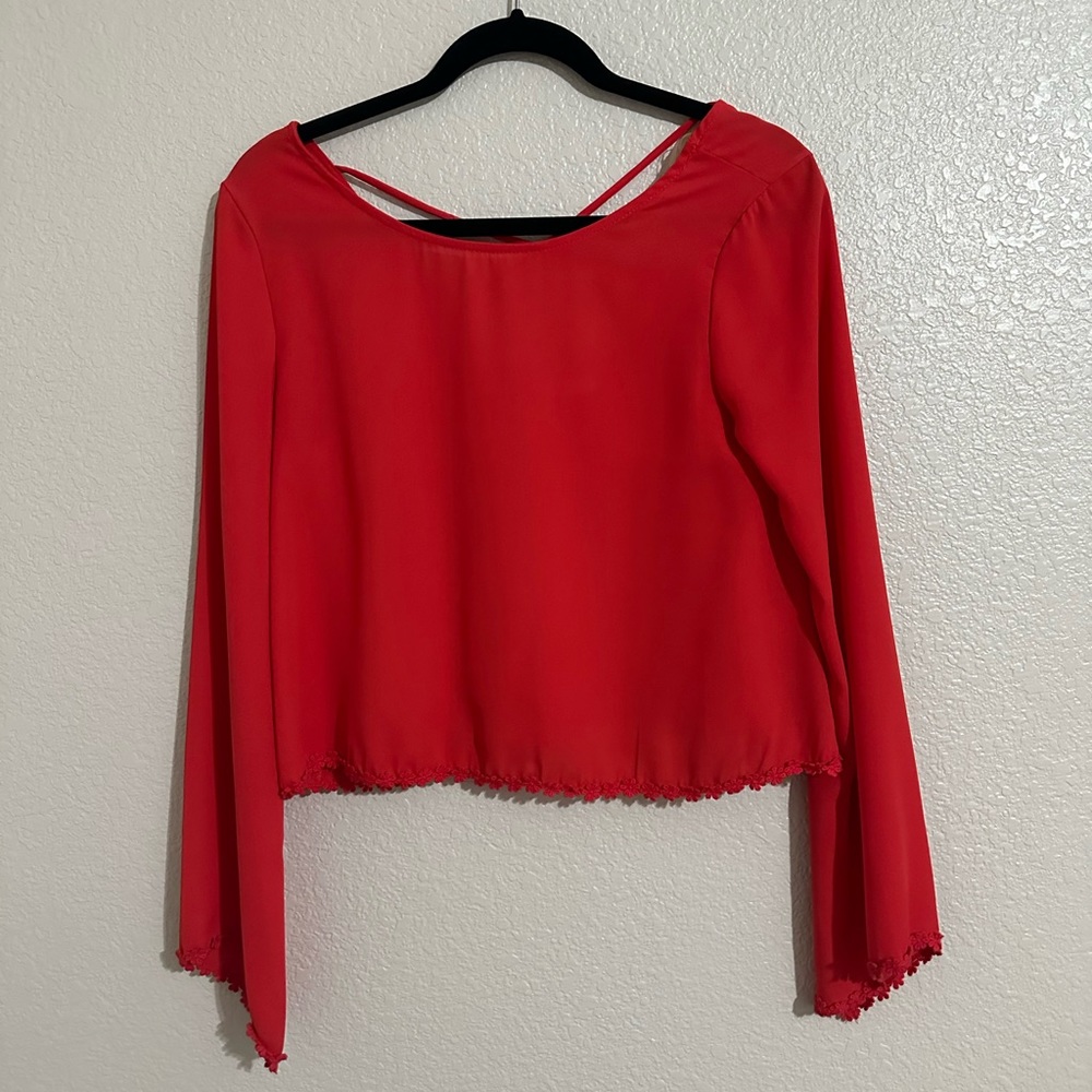 Red flared long sleeve crop top.